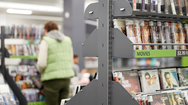 Image of shelving in a library with DVDs visible.