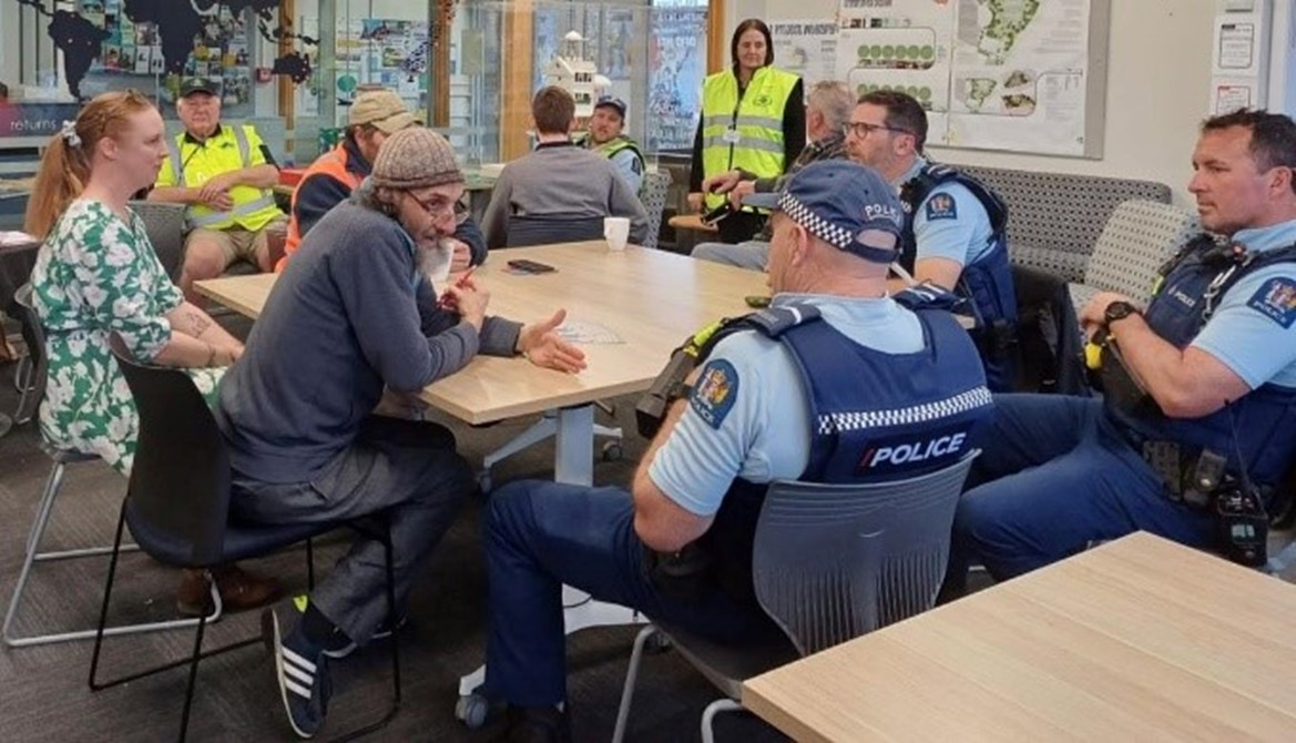 Image of three police officers talking to members of the public around a table