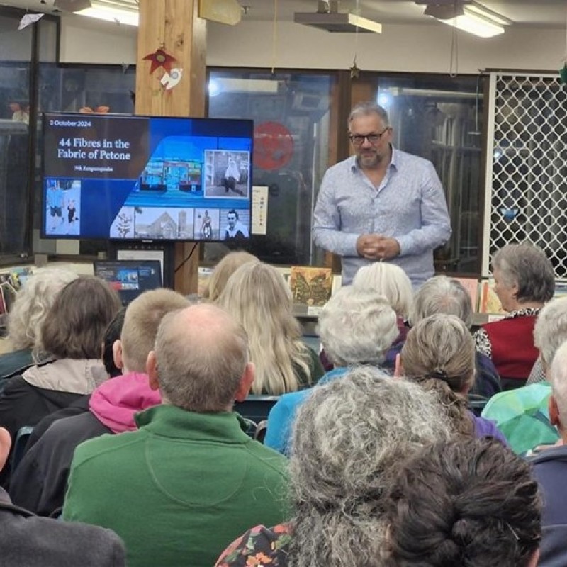 Image of a man presenting to a group of people about Petone
