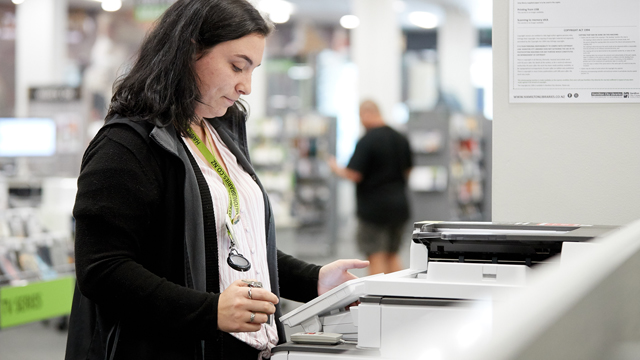 Library staff member using an MFD photocopier