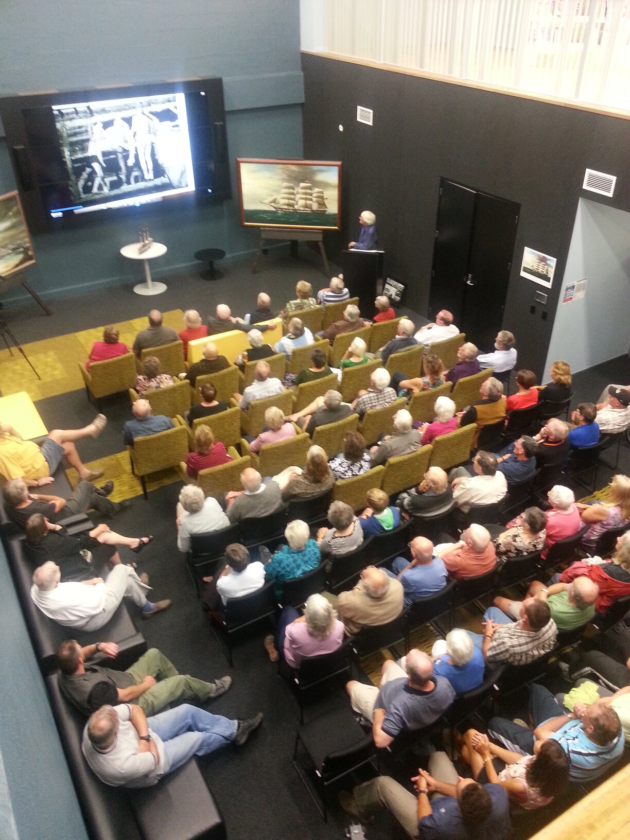 A crowded auditorium watch a presentation