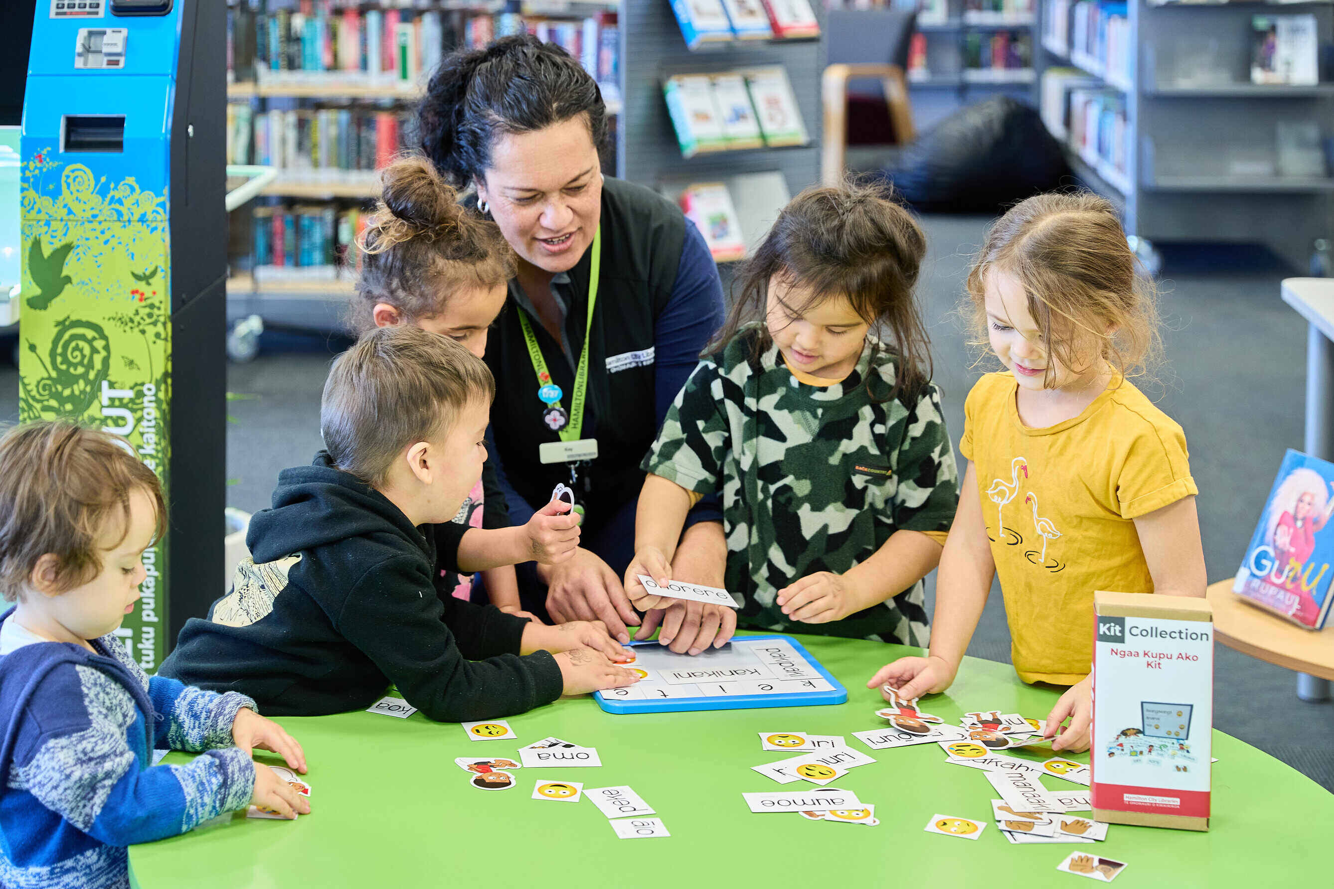 female librarian showing group of kids an activity