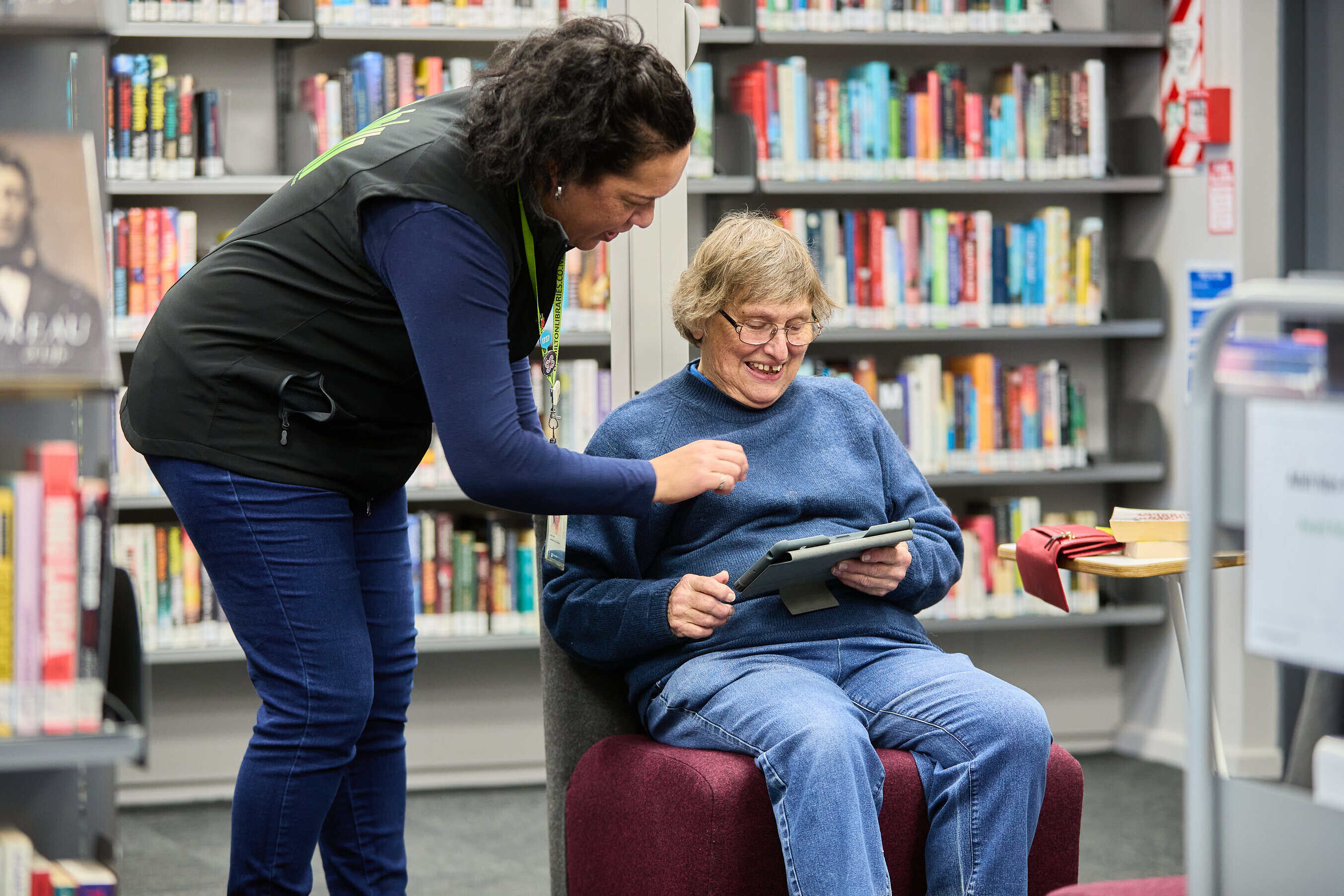 older woman being shown how to do something on an ipad