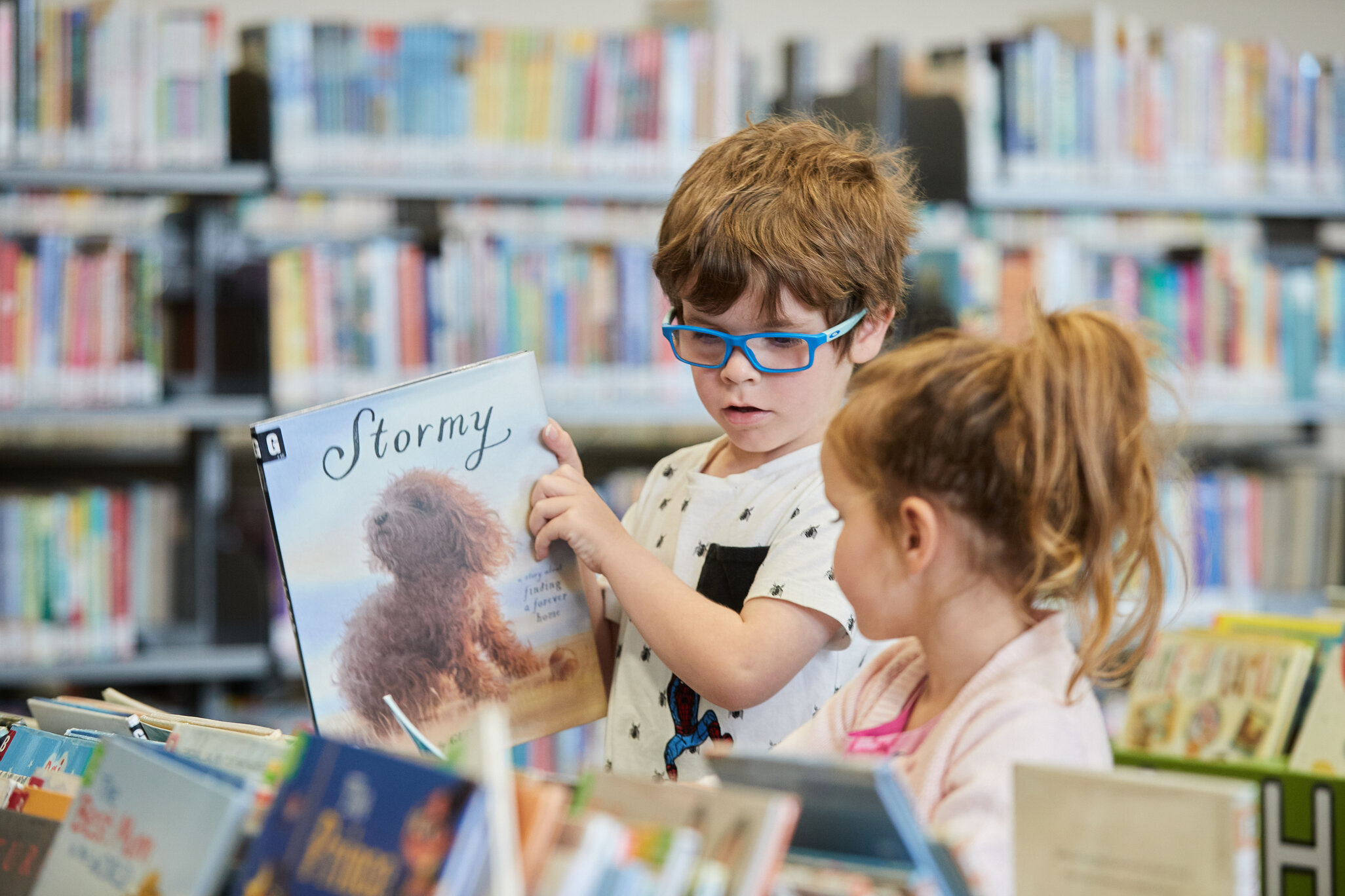 Young boy shows sister his book