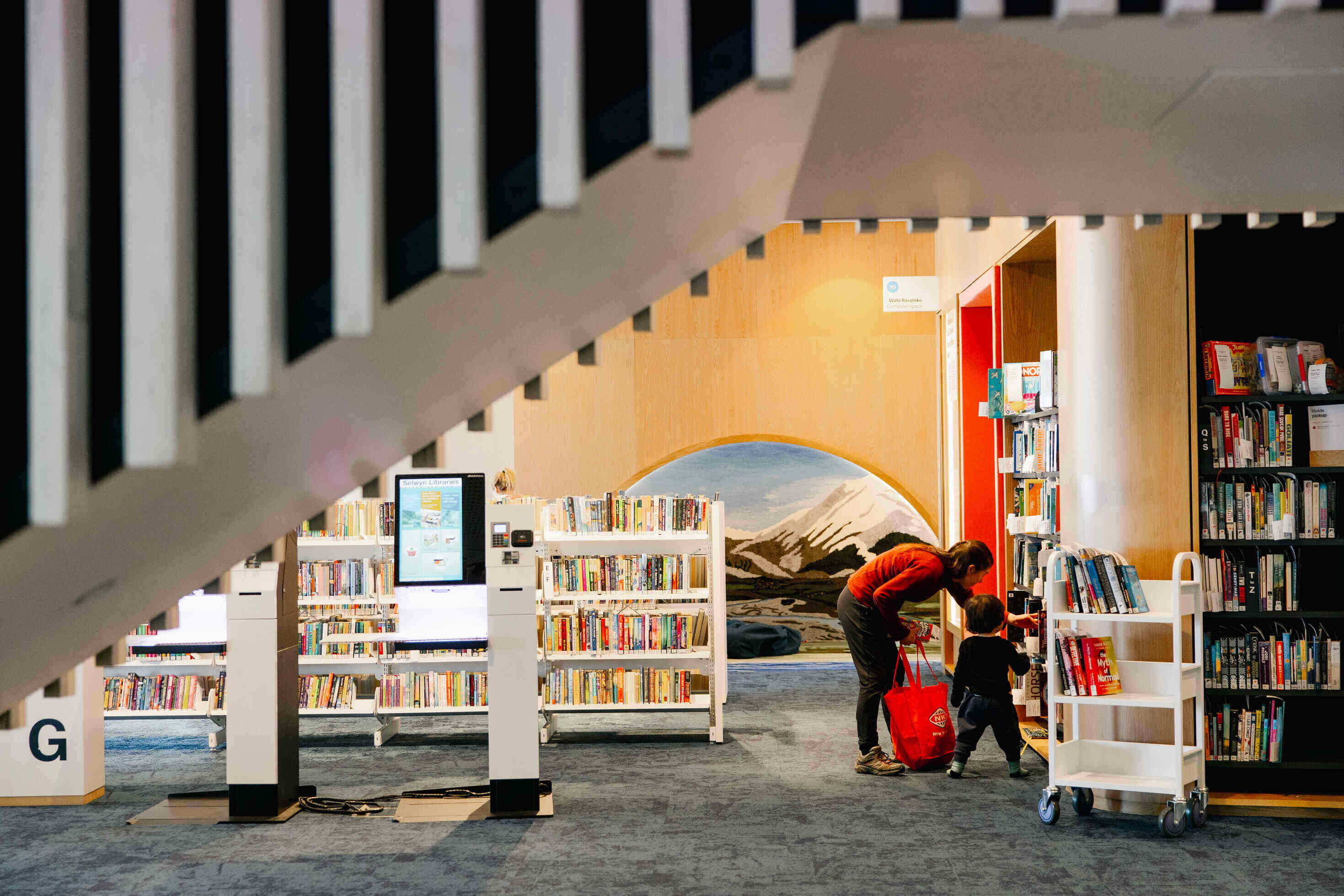 Library interior under stair showing bookshelves rfid and sensory nook