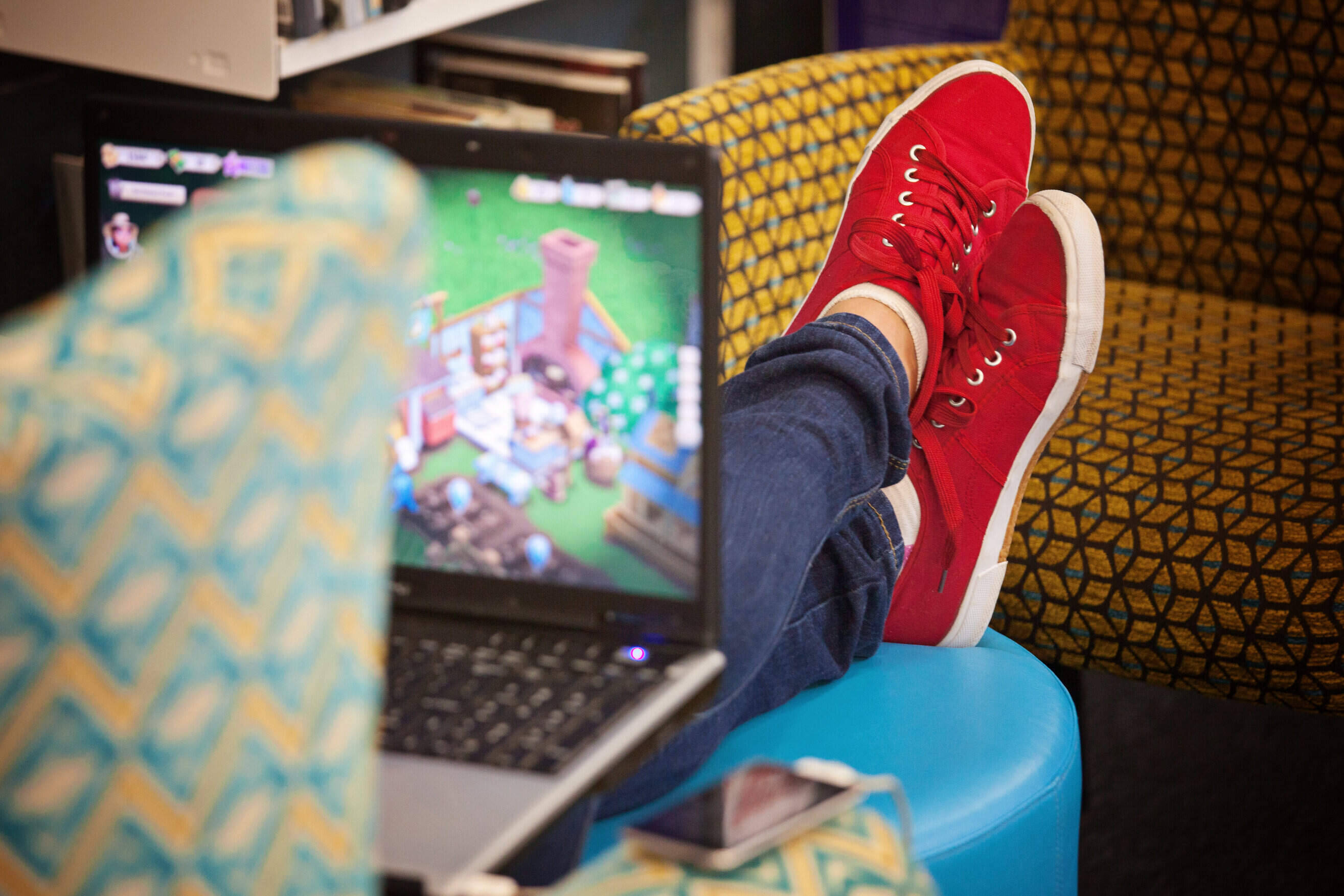 Image of a person in a chair with feet up playing a game