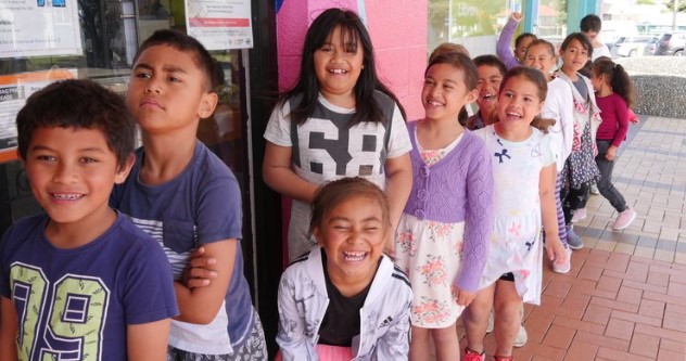 Image showing a row of smiling children standing in front of Cannons Creek Library.