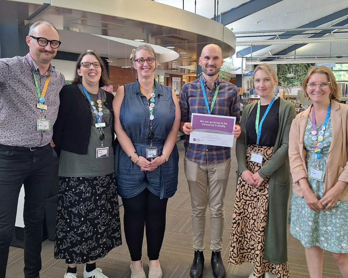 Image showing six Waimakariri Libraries staff members holding a certificate awarded to the for working to be dementia friendly.